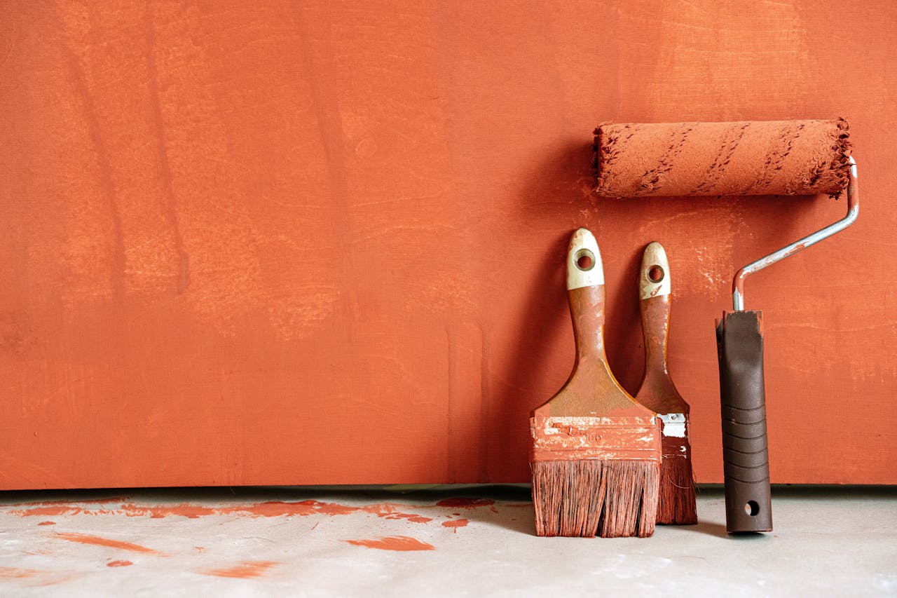 The Art of Drawing Readers In: Your attractive post title goes here Close-up of paint rollers and brushes with orange paint against a painted wall.